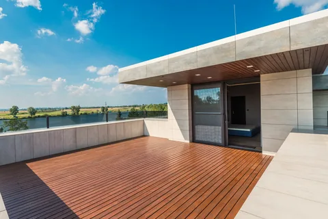 Impermeabilización en Neguri: pide presupuesto. Terraza de madera de una vivienda moderna con cubierta voladiza